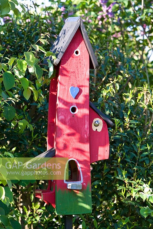Red bird house with bird