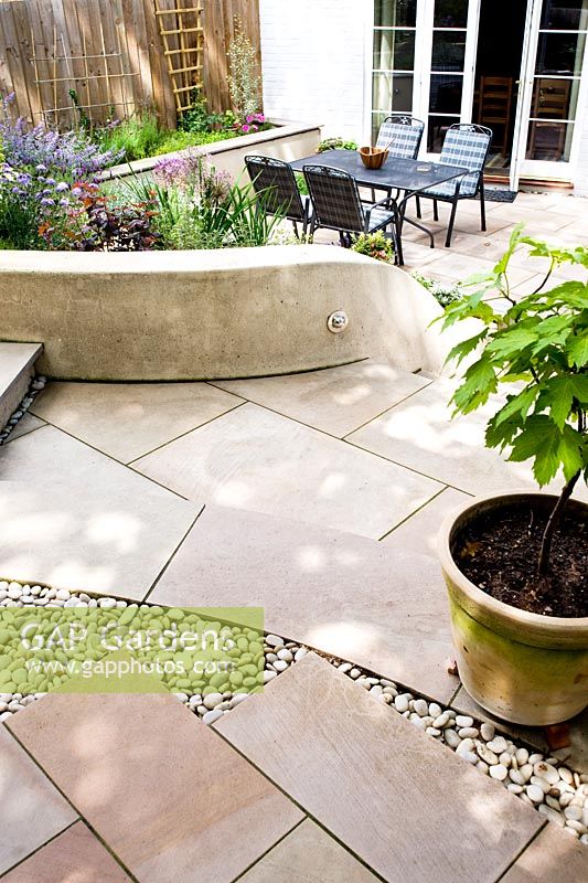 Curving limestone steps in small modern garden. 