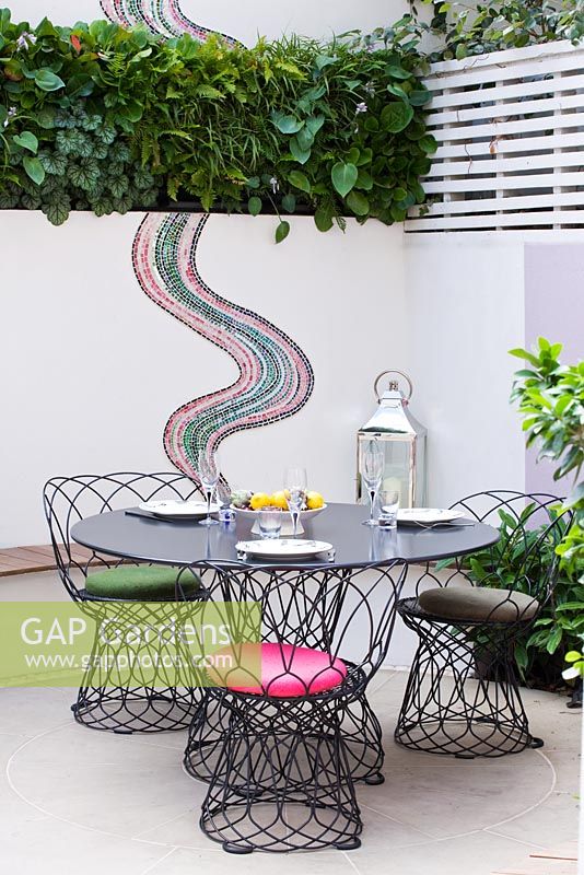 Small patio garden with dining area and mosaic by Celia Gregory, London. 
