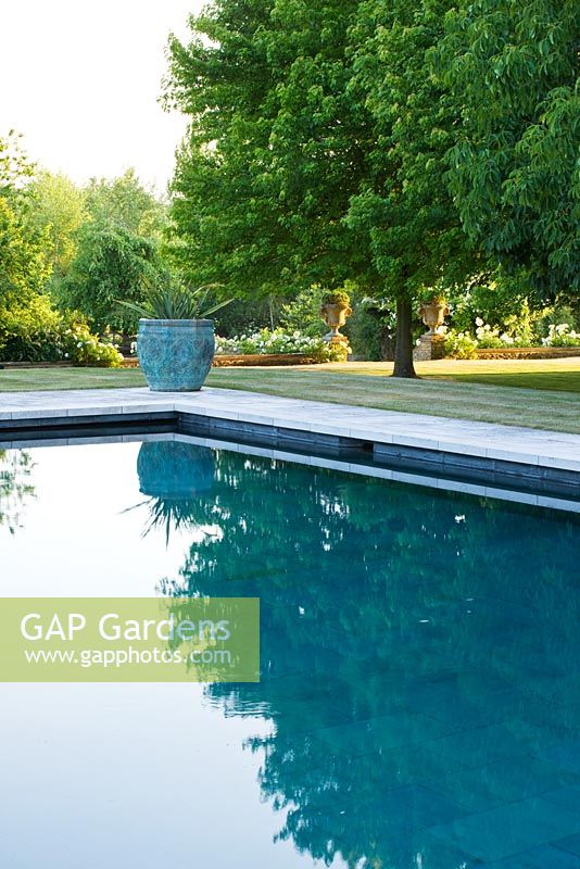 Swimming pool with country garden reflected in it 
