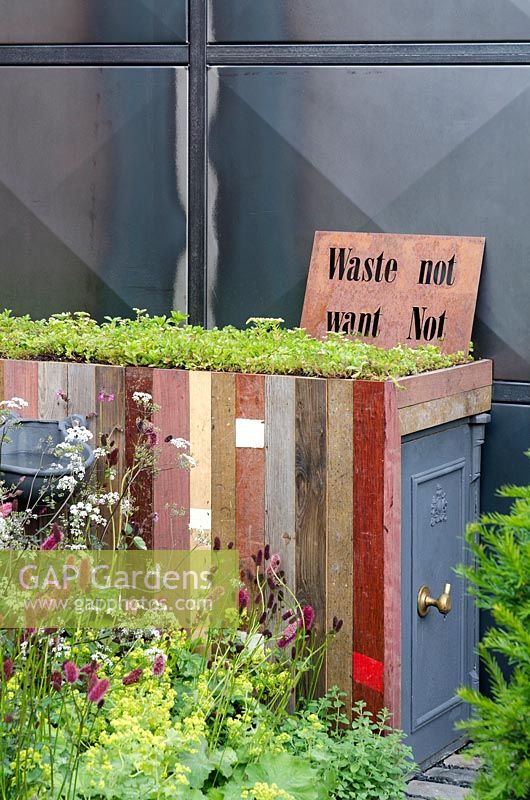 Storage made from recycled wood with 'living roof' next to steel-framed metal structure in the Stockton Drilling Winds of Change Garden, Gold Medal Winner - RHS Chelsea Flower Show 2011 
