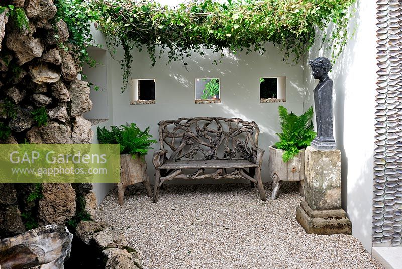 Garden bench made from tree roots in a courtyard garden