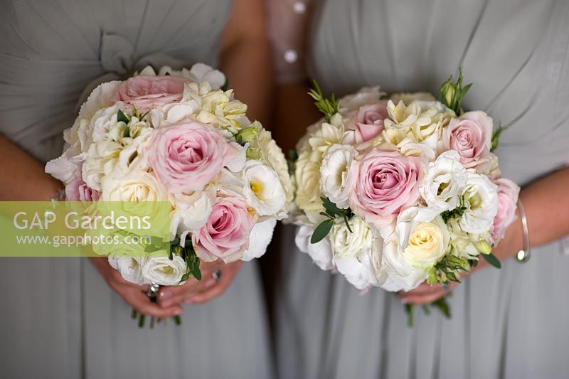 bridesmaids holding wedding bouquets of pink and white roses
