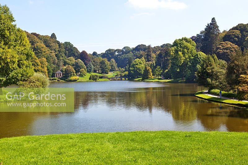 View across lake to the Palladian Bridge and the Temple of Flora at Stourhead Gardens, Wiltshire, UK, early September, Designed by Henry Hoare
 