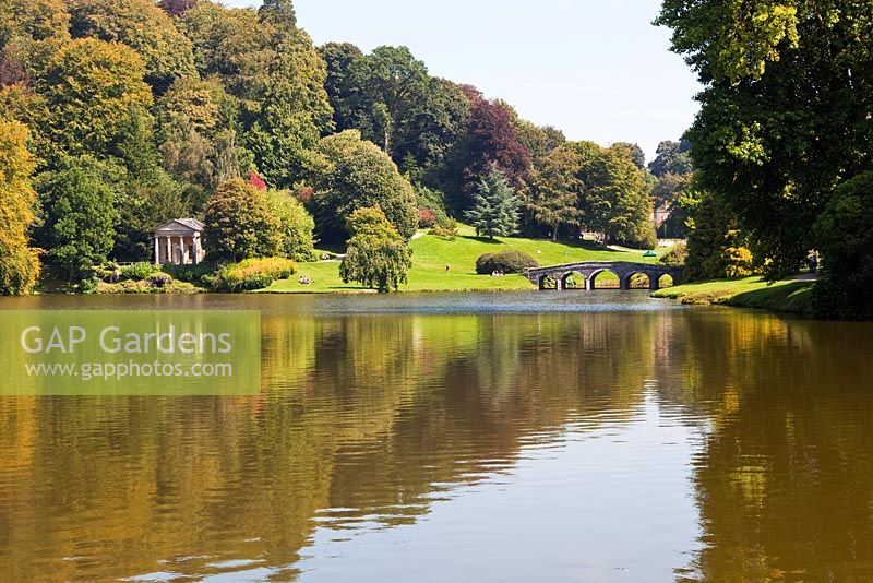 View across lake to the Palladian Bridge and the Temple of Flora at Stourhead Gardens, Wiltshire, UK, early September, Designed by Henry Hoare 