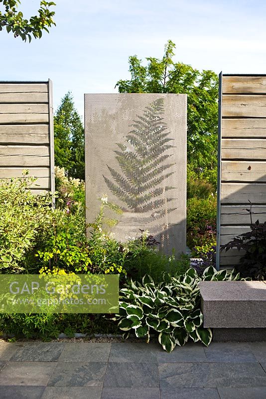 Concrete wall and wooden fences in modern garden 