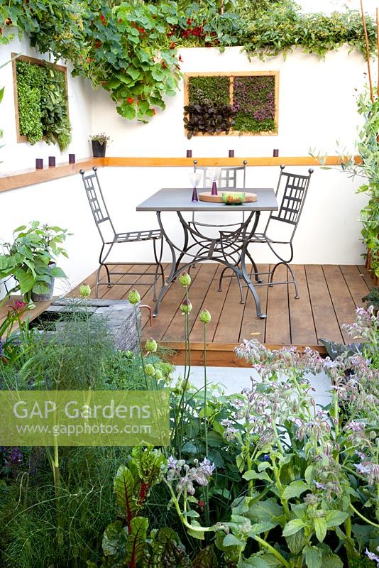 Table and chairs on modern decked terrace The Potential Feast Design - Raine Clarke-Wills Hampton court flower show 2011