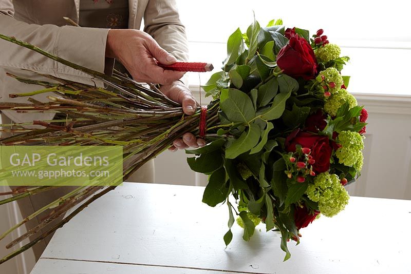 Making floral bouquet - Gaultheria 'Shallon green' , Hypericum, Pttosporum, Rosa 'Red naomi'  and Viburnum