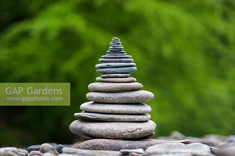 Stacked flat pebbles in a pyramid shape in the english countrside