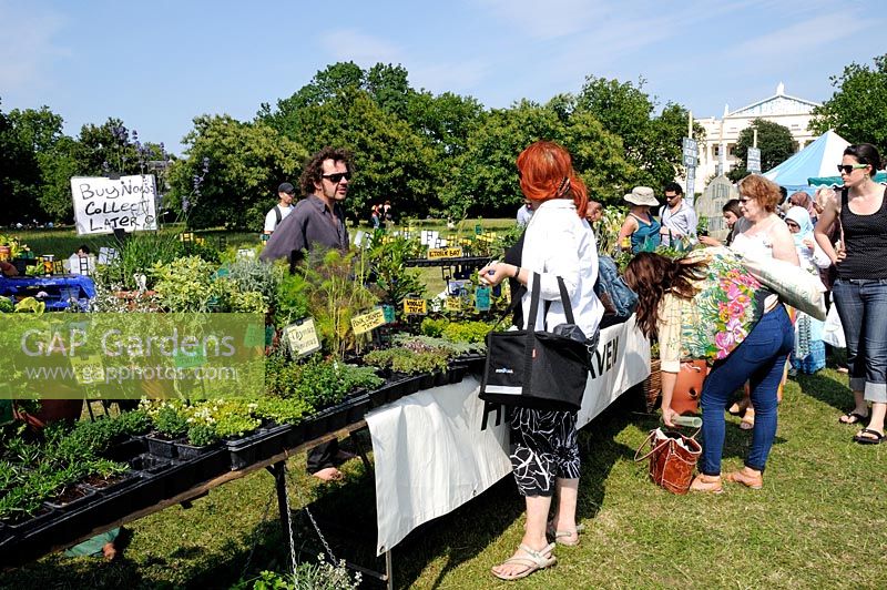 People around a stall selling herbs at Camden, now London Green Fair, Regent's Park, Central London, UK 