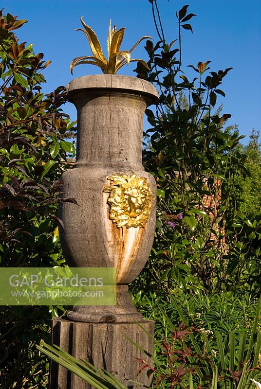 Turned oak urns decorated with gilded lions' heads and agaves are a feature of the upper level of the Collector Earl's Garden designed by Julian and Isabel Bannerman. 