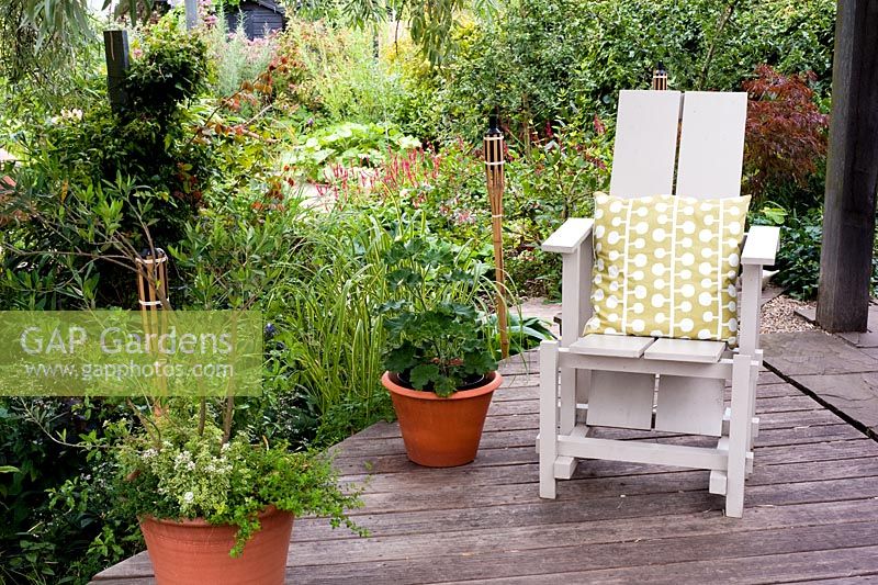 Raised deck with adirondack chair, pots and candles - Brook Hall Cottages, Essex NGS
