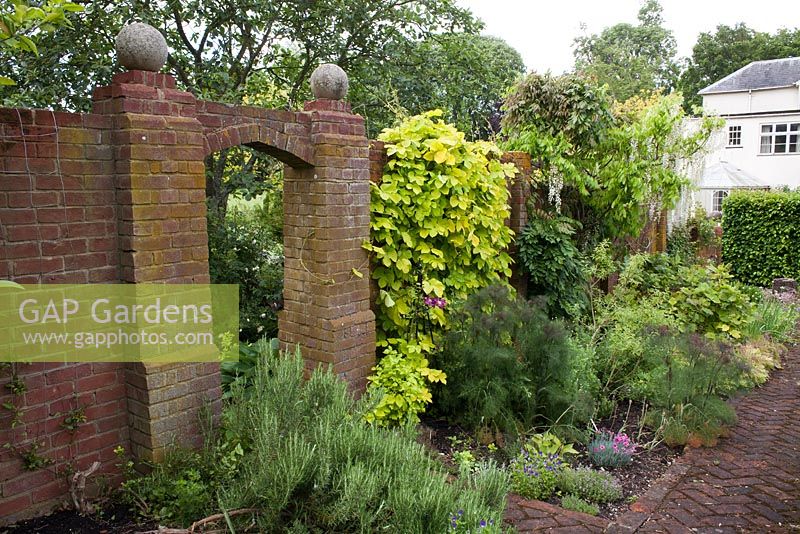 Brick archway in herb walled garden.