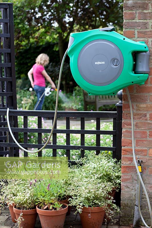 Woman using wall mounted hose