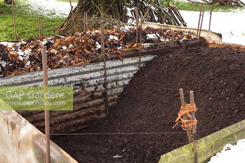 Large compost bin containing composted leaf mould 