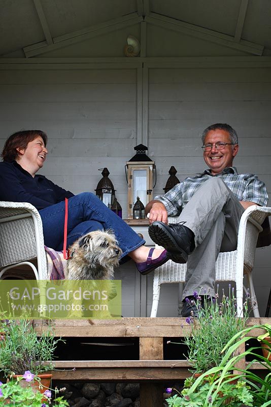 Barry and Mandy Milton in their summerhouse with their border terrier, Monty - The Lizard, Wymondham, Norfolk