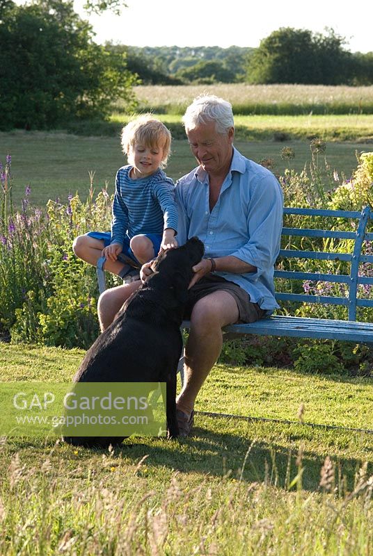 Andrew Singleton with his son William and the family Labrador by the yellow and blue borders. Wood Farm, June