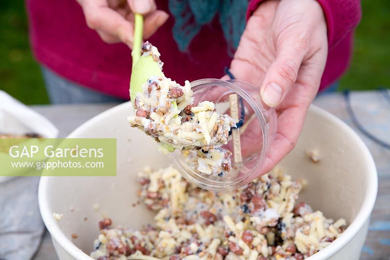 Step by step for creating hanging bird feeders out of teacups and yoghurt pots - adding mixture 