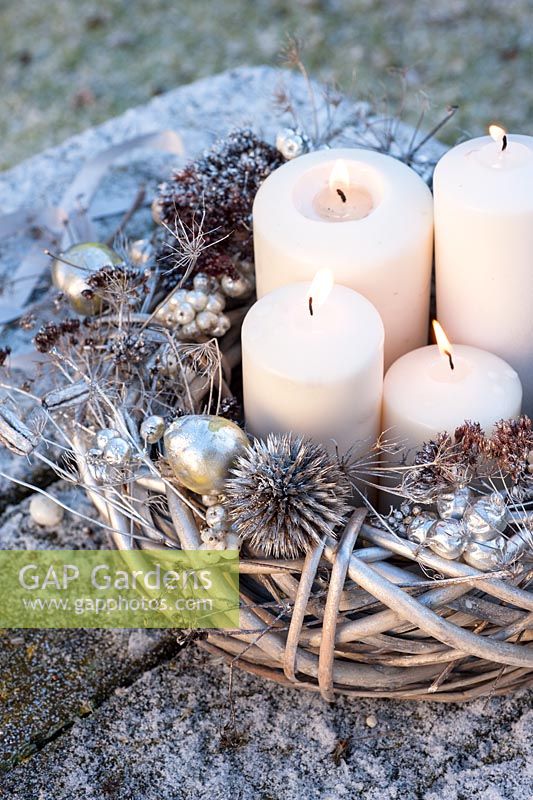 Christmas arrangement with sprayed wreath, candles and collected seedheads