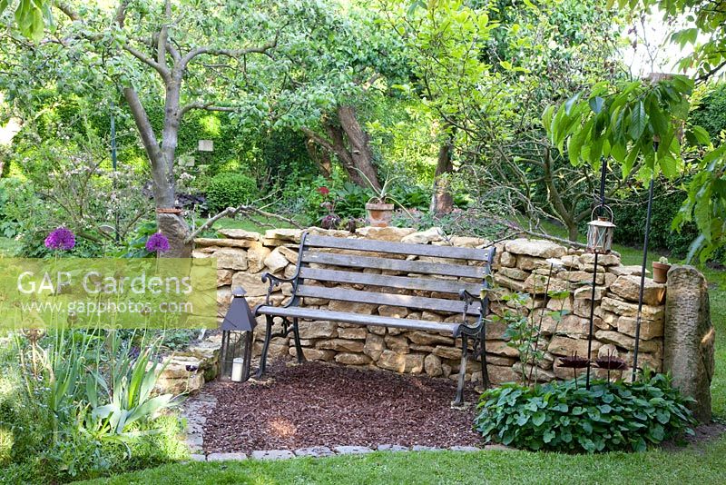 Rustic bench in front of stone wall