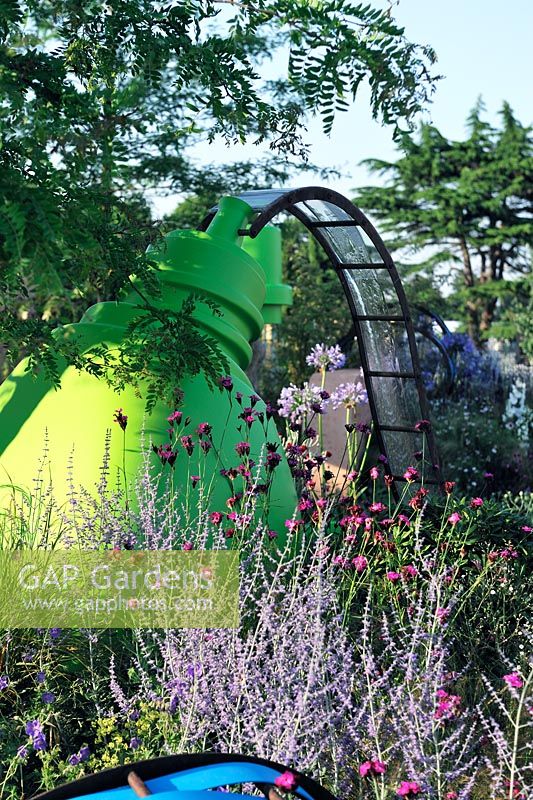 Water feature. Water chute running from large bottle. Planting includes, pervoskia, blue spire, Dianthus, carthusianorm, The Ecover Garden RHS Hampton Court Flower Show 2013 Design -  Mathew Childs