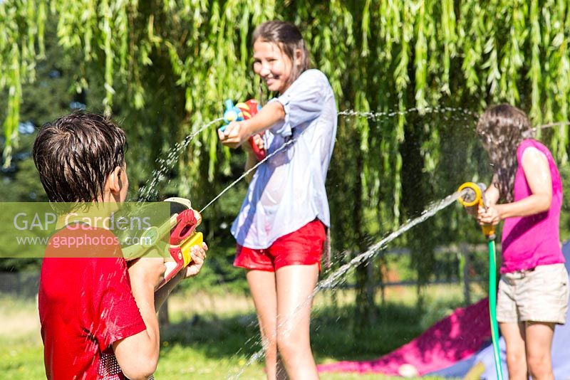 Children having a water fight in the garden