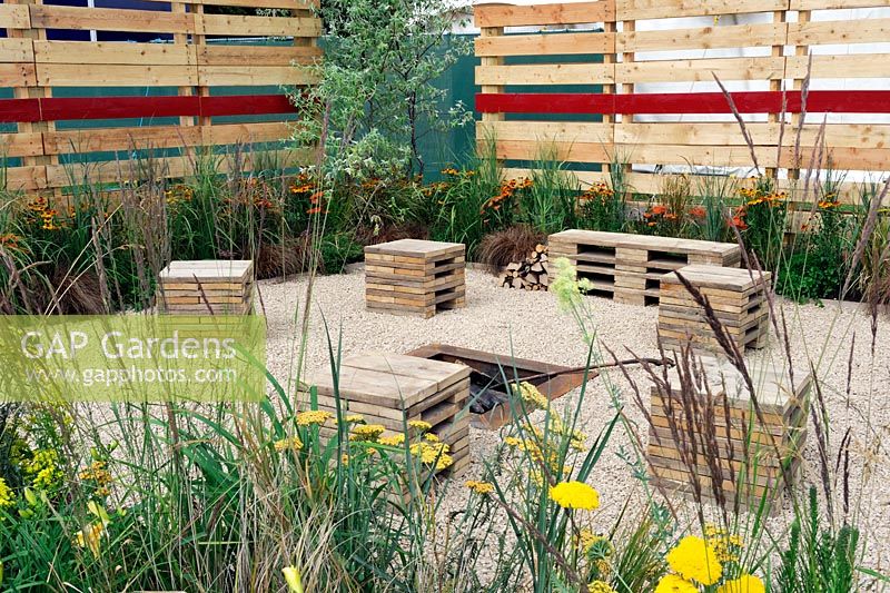 Recycled scaffolding board bench and small seats in gravel patio. The Bees Garden. RHS tatton Park Flower Show 2013