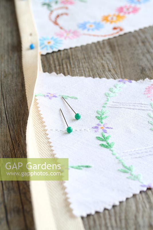 Step by step of making garden bunting with vintage linens and buttons - Pin the triangles up inside the fold of the ironed webbing