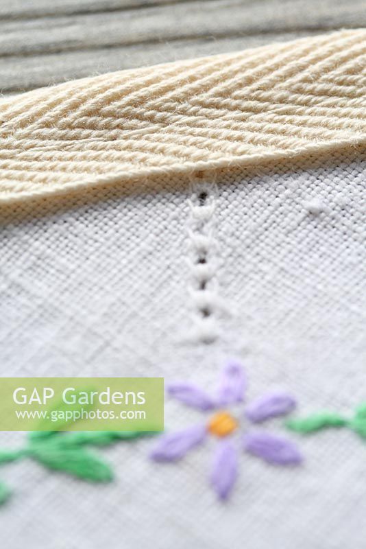 Step by step of making garden bunting with vintage linens and buttons - Detail of straight stitch along the top of the bunting