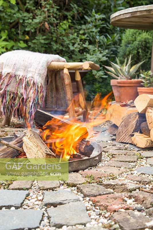 Firepit made from a dustbin lid with surrounding seating area