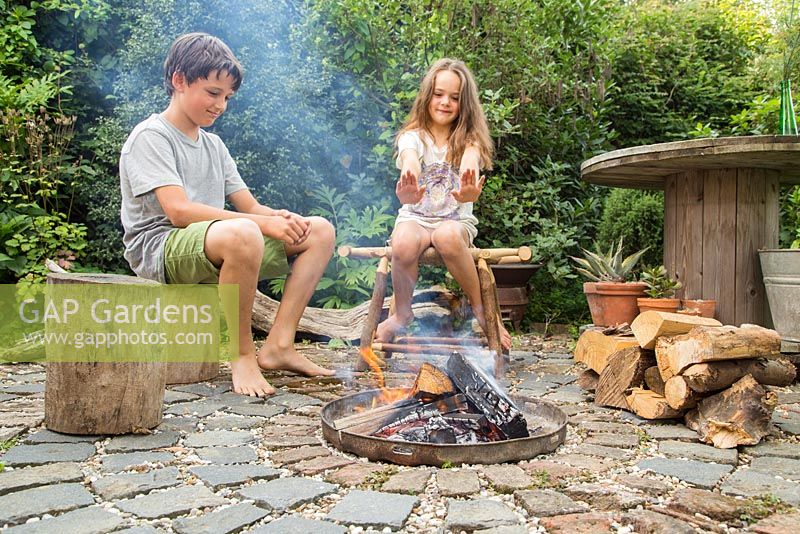 Firepit made from a dustbin lid with surrounding seating area