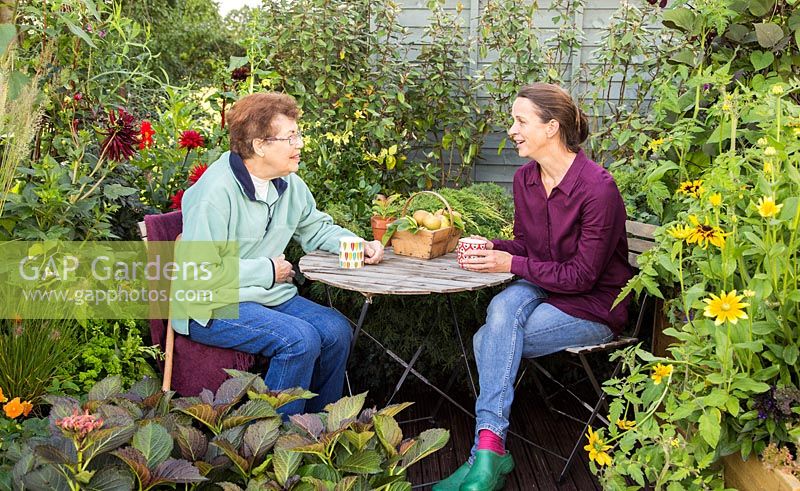 Mixed generations drinking tea in a small urban garden