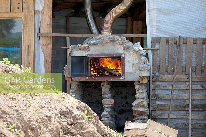 Burning wood inside pizza oven.