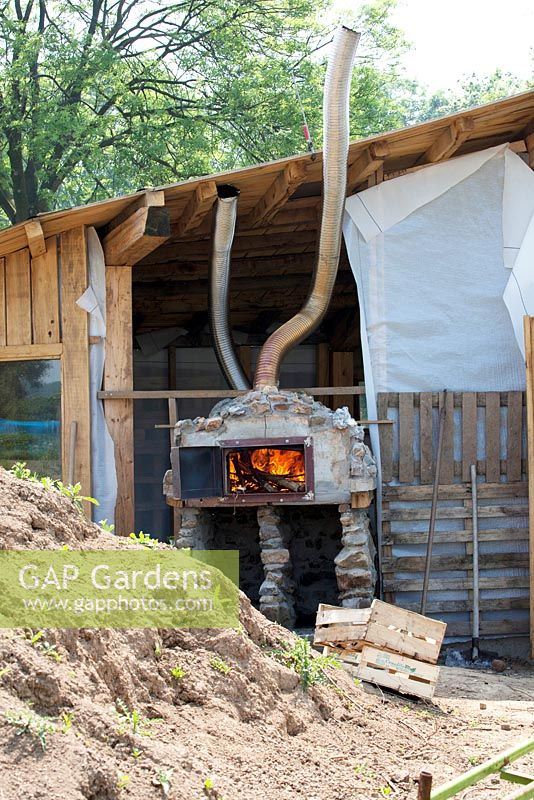 Preparing the pizza oven by burning wood.
