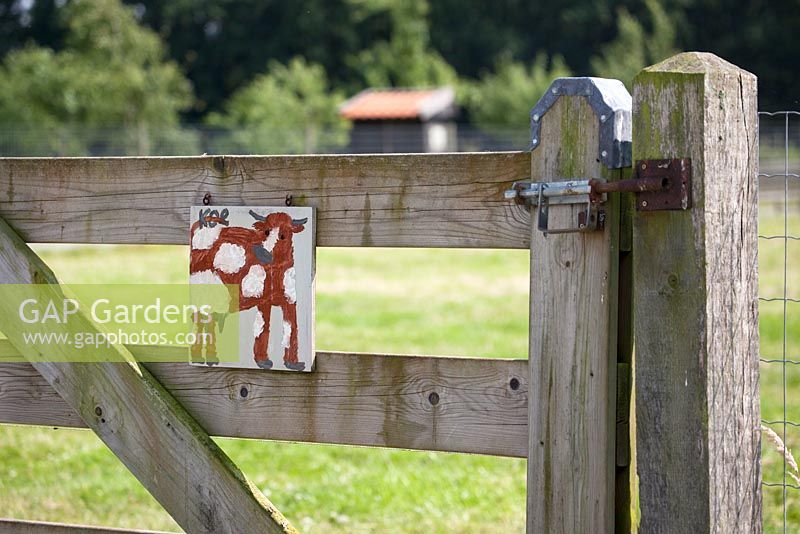 Painted cow on a fence to show where the cows are kept