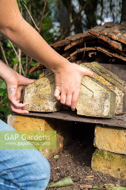 Young girl adding bricks for the roof