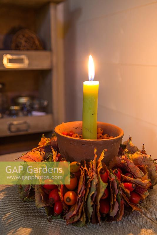 Candle holder decorated with Acer rufinerve leaves, Rose hips and Pyracantha berries