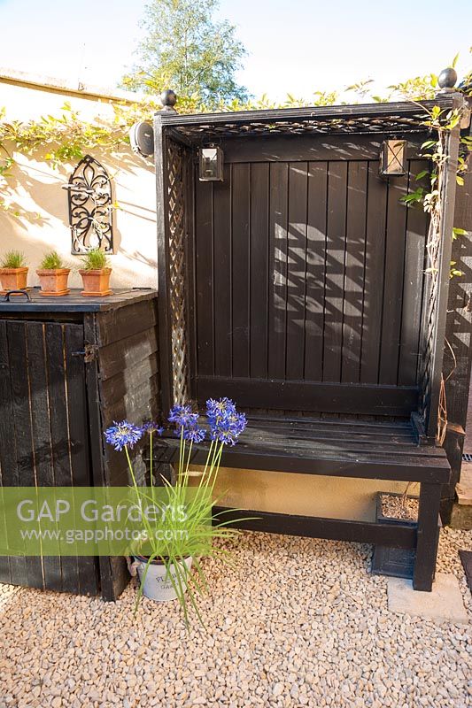 Black woodwork and cream walls make a striking combination in the back garden with constructions including a cupboards for compost bins and a built in bench. 