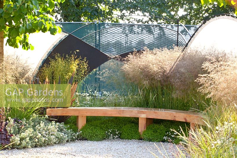 Modern garden with shelter. Plants include Phormium, Deschampsia cespitosa, Deschampsia cespitosa 'Goldtau' and Thymus vulgaris