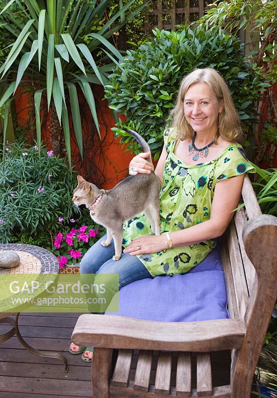 Karla Newell in the garden with pet cat, Mixie. Brighton, UK 