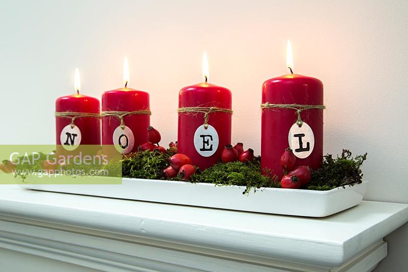 Christmas candle decorations spelling NOEL, made using Rose Hips and moss