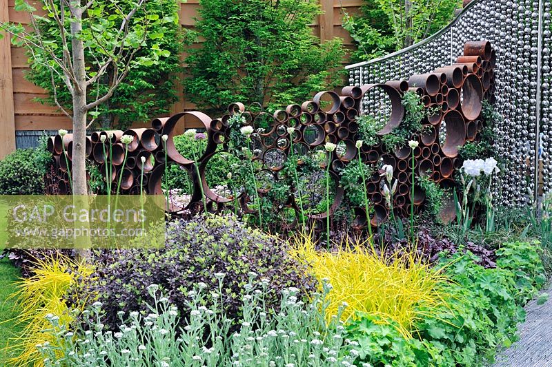 The SeeAbility Garden, Rusting metal tubes structure and steel sphere curtain along flower beds