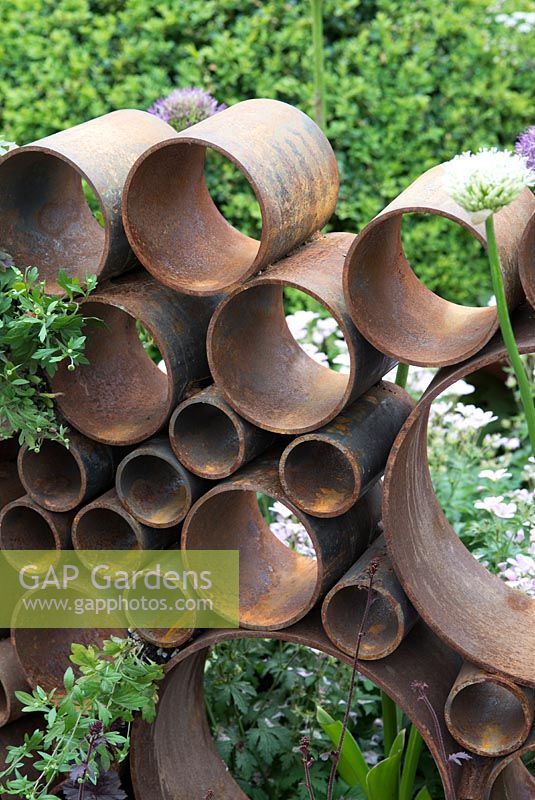 SeeAbility Garden, rusty metal cylinders in border