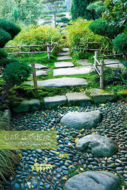 Stone pathway though Japanese garden with bamboo edging and bamboo