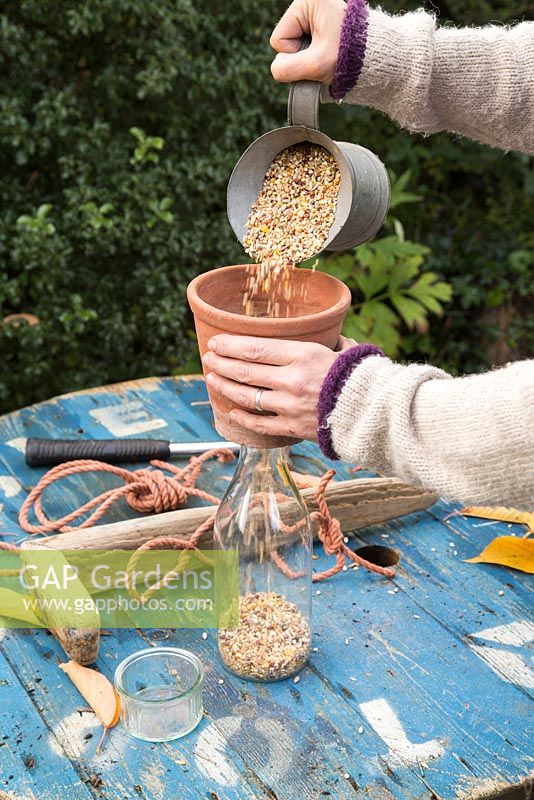 Using terracotta pot to pour in bird feed.