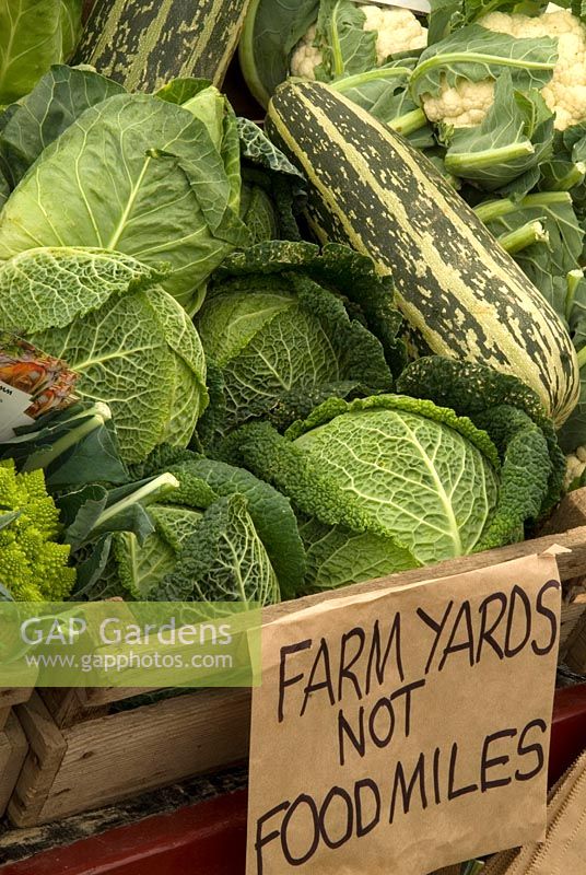 Vegetables on market stall, with green message about food miles