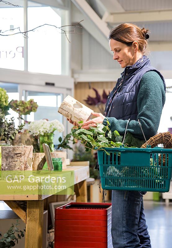 Woman browsing selection of household items at a garden nursery