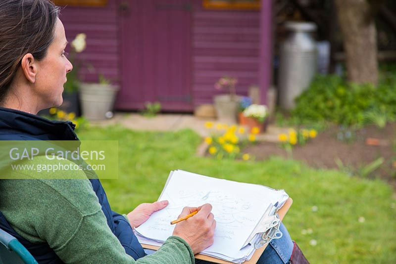 Woman sat in deck chair garden planning