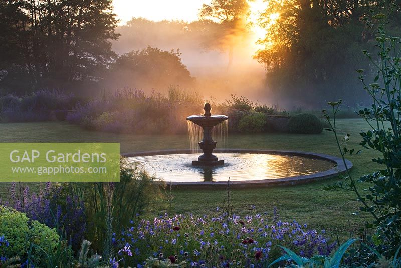 Dawn light on the fountain near the blue garden. Narborough Hall Gardens, Norfolk