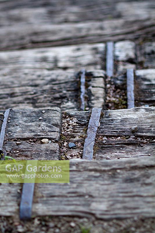 Antique hand made metal braces for fixing heavy oak steps within garden setting. Jardin des Paradis, Cordes-sur-Ciel, Tarn, France.